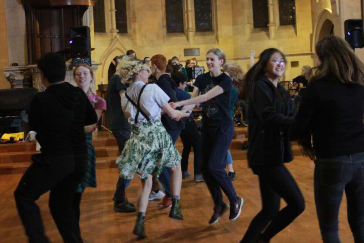 Some people dancing in a church in front of the band